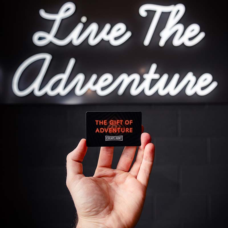 A hand holding an Escape Hunt gift card